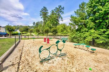 a park with a playground and trees in the background